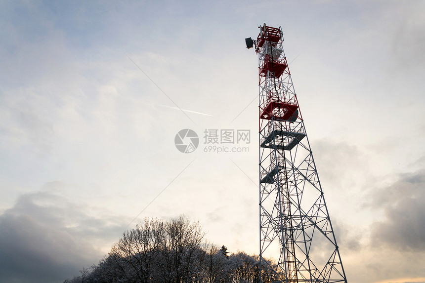 白雪皑的冬日落时红白电信塔上的发射器和天线图片