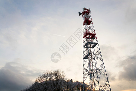 白雪皑的冬日落时红白电信塔上的发射器和天线图片