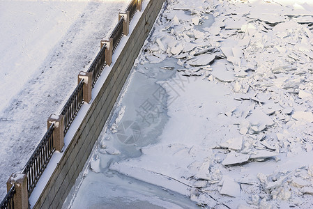 寒冷河流的冬季城市堤防图片