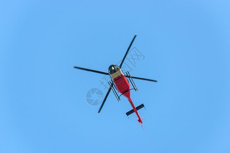 红色和白色直升机飞往蓝天飞行图片