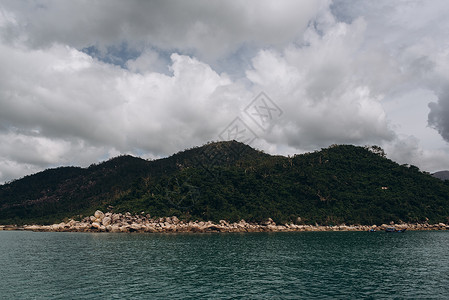 背景为大海和灰色天空的岛屿近景图片