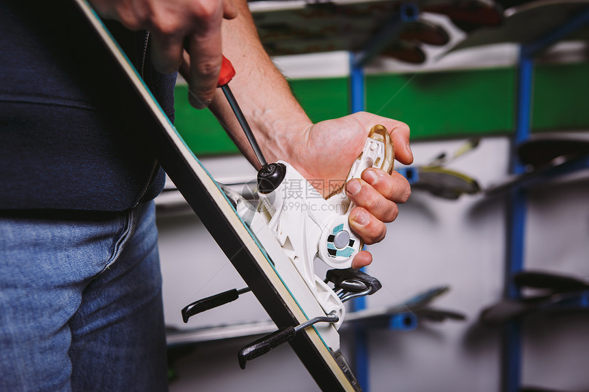主题酊剂和修复滑雪设备滑雪一名白人男子手的特写镜头使用手持螺丝刀工具在车间内调整扭曲图片