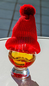 酒杯中一杯纯麦威士忌红帽子奢华品味饮料图片