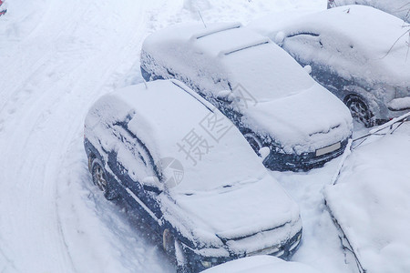 降雪期间下雪的停放汽车的顶视图图片