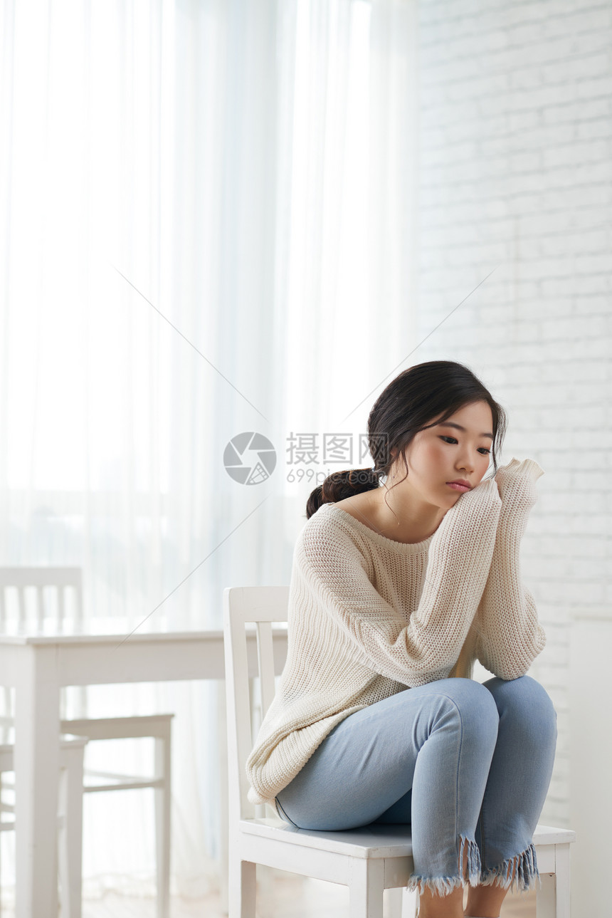 坐在家里悲伤沉思的韩国女孩图片