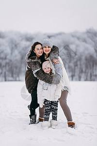 家人一起站在一起拥抱冬公园背景的图片