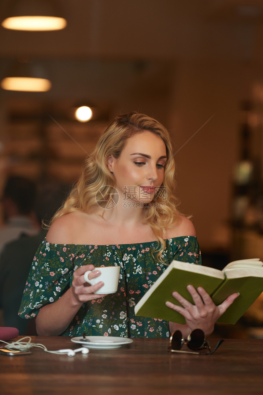 在咖啡店看书的金发美女图片