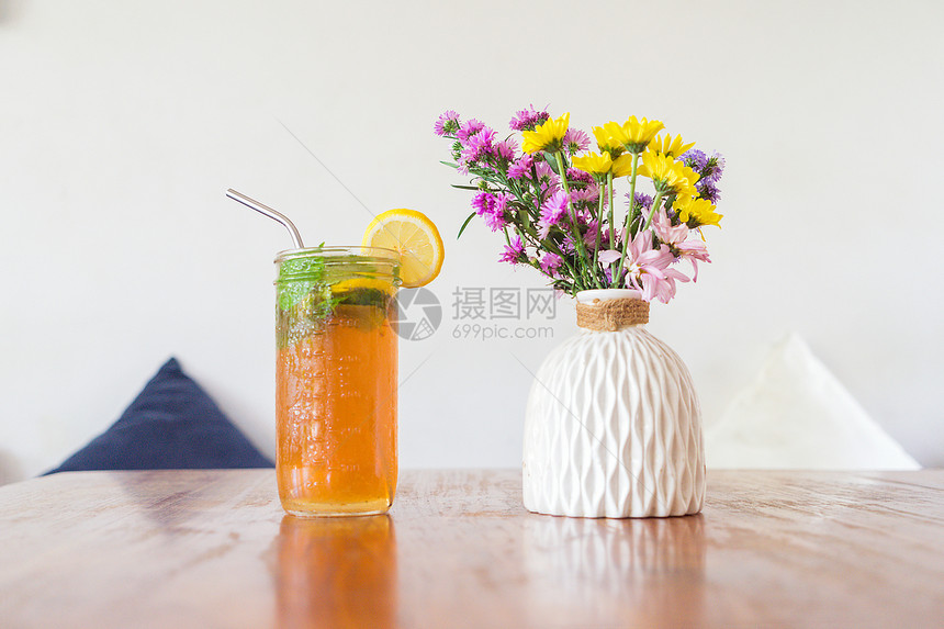 一杯冷茶或柠檬水杯木制桌边的花亭咖啡图片