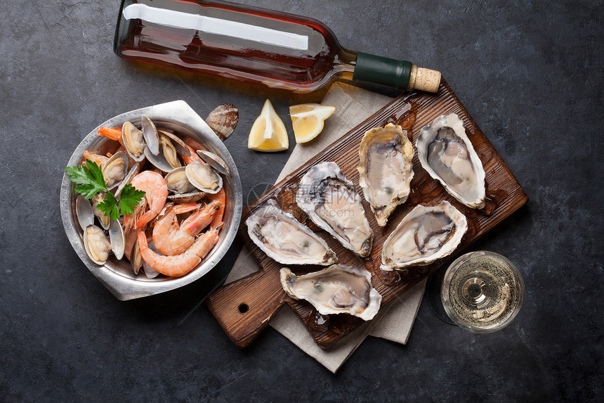 石头桌上的新鲜海和白葡萄酒牡图片