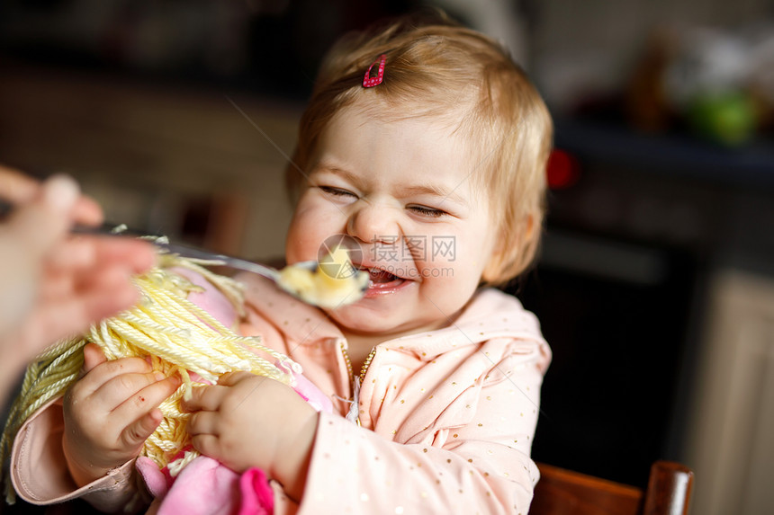 可爱的女婴用勺子捣碎的蔬菜和果泥吃东西图片