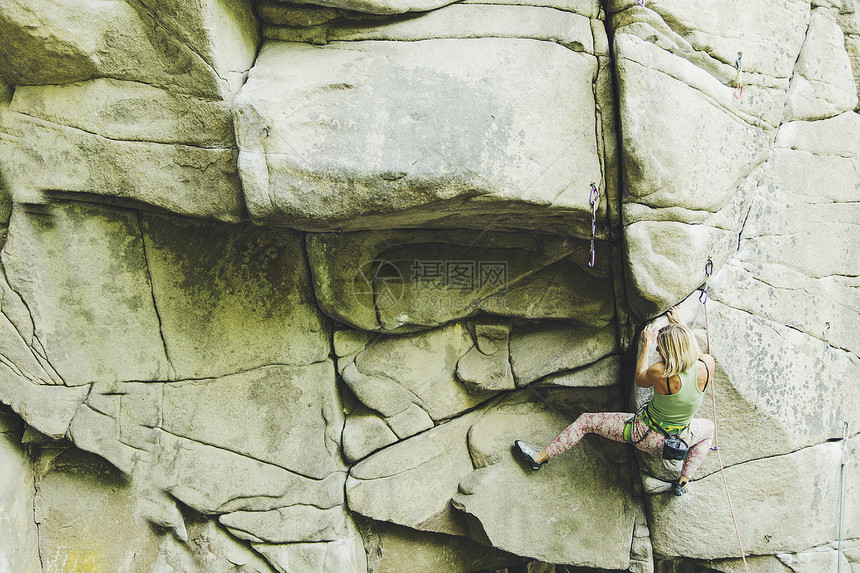 女孩在攀登路线上攀登岩石图片