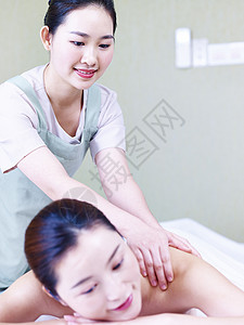 年轻时的按摩师在美容疗养院为女客户提供按摩服务图片