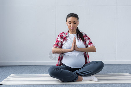 非洲裔美国孕妇在垫子上练习瑜伽图片