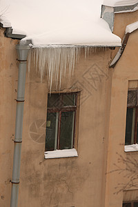 从窗户上方的排水管垂下的冰柱图片