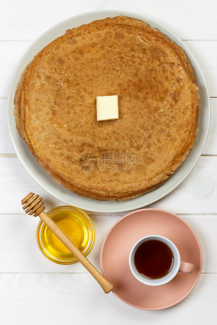 盘子里有黄油和蜂蜜的热煎饼图片