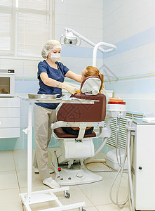 医生牙科医生用现代设备在牙科诊所为她的病人图片