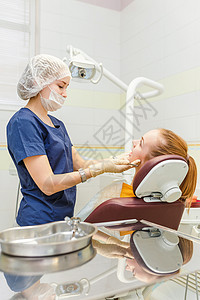 医生牙科医生用现代设备在牙科诊所为她的病人图片