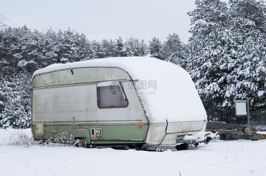 冬季森林景观下着雪的破碎旅游车拖停在图片