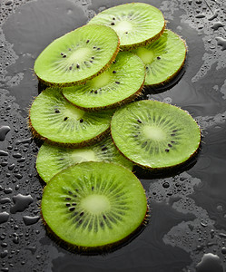 黑底水滴中的片水果概念图片