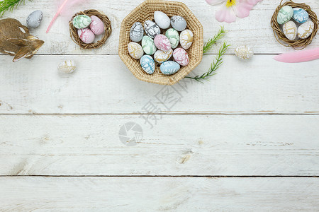 在办公桌上现代质朴的白色木头上平躺着五颜六色的复活节彩蛋图片