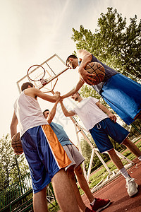 四个篮球运动员在训练前打过体育问候他图片