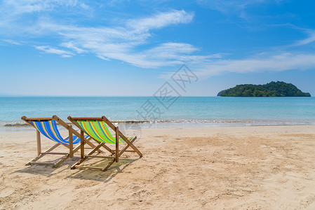 两张沙滩椅在白沙上图片