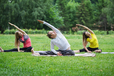 一群瑜伽运动员夏天在公园做呼吸锻炼图片