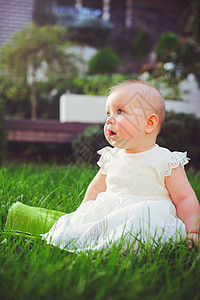 半岁儿童坐在院子里的草地上图片