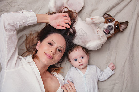 年幼母亲和有狗的小孩躺图片