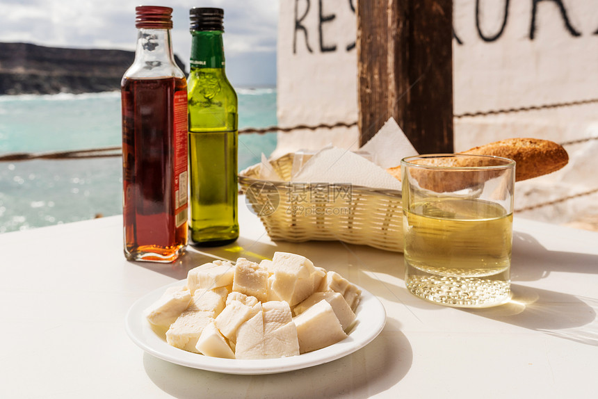 山羊奶酪橄榄油醋白面包和白葡萄酒在桌外露天拍图片