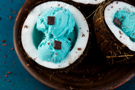 蓝冰淇淋和椰子碗里的巧克力在木质背景图片