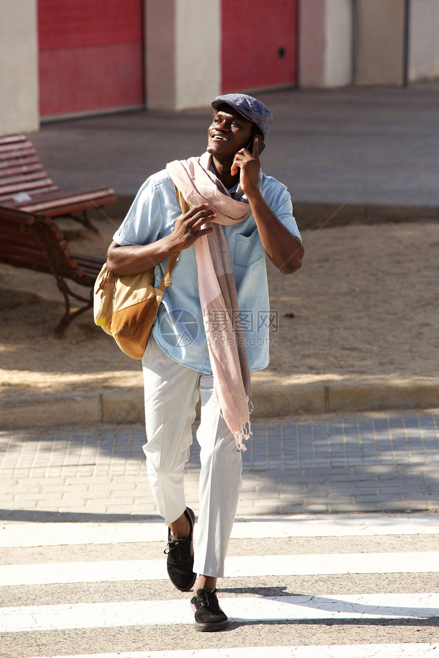 英俊的非洲男子在城市外通过电话交谈的全图片