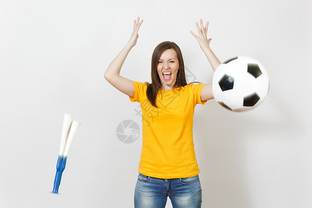 美丽的欧洲年轻快乐的女人足球迷或穿着黄色制服的球员投掷足球管图片