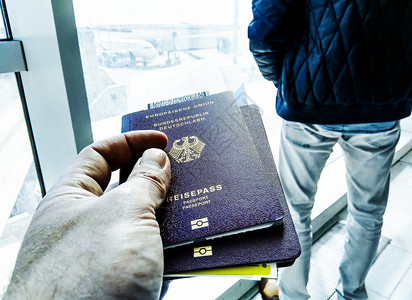 持有护照和机场大门登机证的男手图片