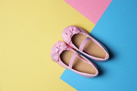 黄色蓝色和粉色背景上一双粉色漆皮鞋的高角度视图图片