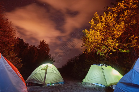在星空下的山上发光的帐篷图片