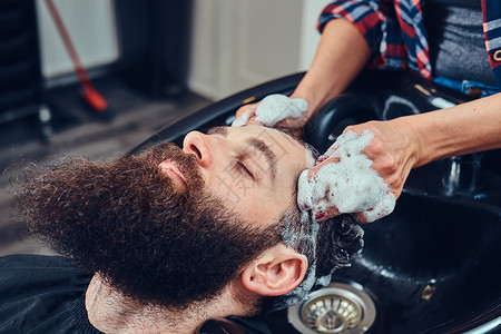 专业美发师在理发店为客户洗头图片