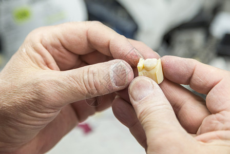 男牙科技术员在实验室用3D打印的假牙图片