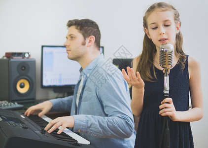 男的和小女孩一起在音乐工作室排练歌曲图片