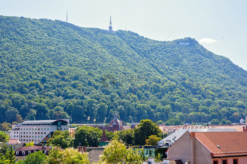 对好莱坞式布拉索夫的日光晴朗的看法在罗马尼亚签到山上的绿树和建筑物的屋顶明亮图片