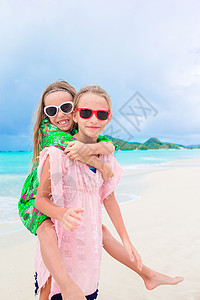 小女孩在热带海滩玩得很开心在浅图片