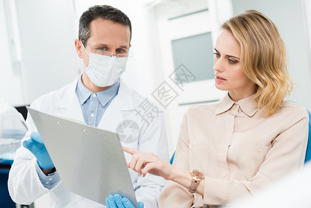 医生和微笑的病人在现代牙科诊图片
