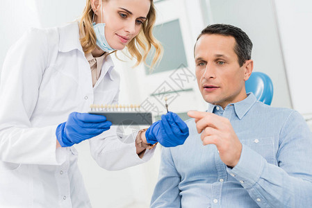 女医生和病人在现代牙科诊所中选图片