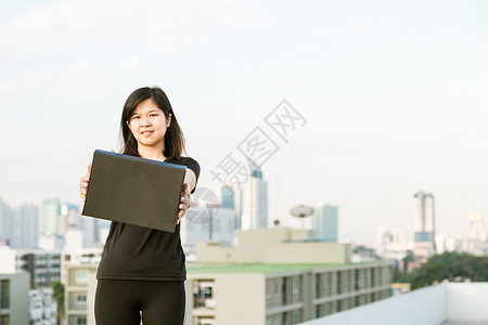 体育女运动员在现代建筑空中跳伞背景上图片