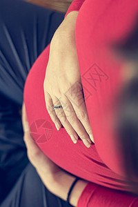 母亲抱着怀孕的肚子要生孩子了在下方图片