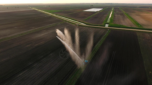 灌溉设备浇灌新鲜播种的田地灌溉农田以确保作物的质量鸟瞰图图片