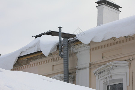 雪从屋顶垂下城市景观图片