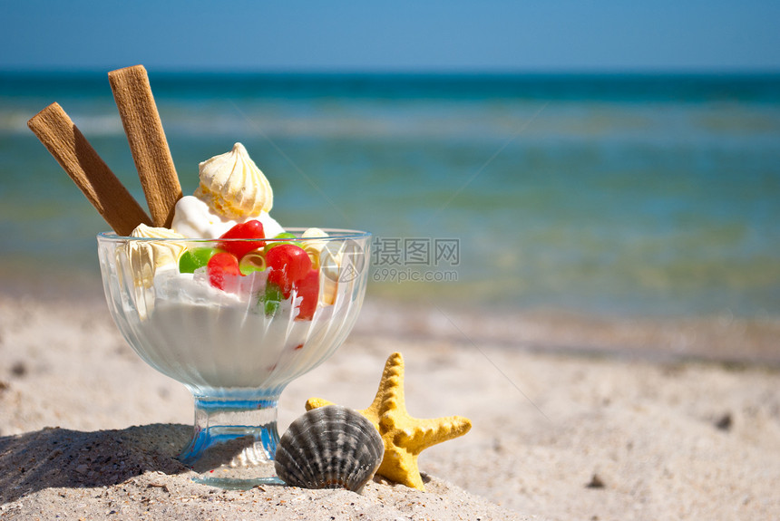 白色美味甜点冰淇淋多色糖果衣长饼干放在玻璃甜点花瓶里美味的甜点旁边黄色海星和灰色圆壳站在黄图片