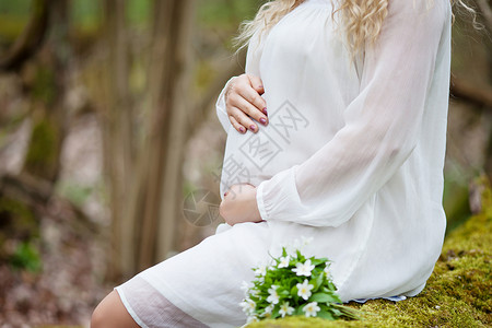 孕妇用手抚摸腹部的特写图像图片