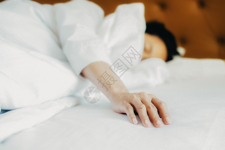 美丽的亚洲懒惰女人睡在床上晨光照图片